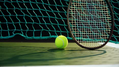 Tennis-ball-and-racket-against-net-in-court-4k