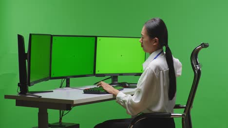 woman experiencing back pain while working at a computer