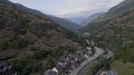 slow drone reveal of pyrenees mountains in spain with town below on a mostly clear day