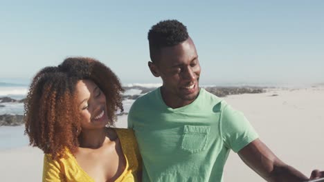 african american couple taking selfie seaside