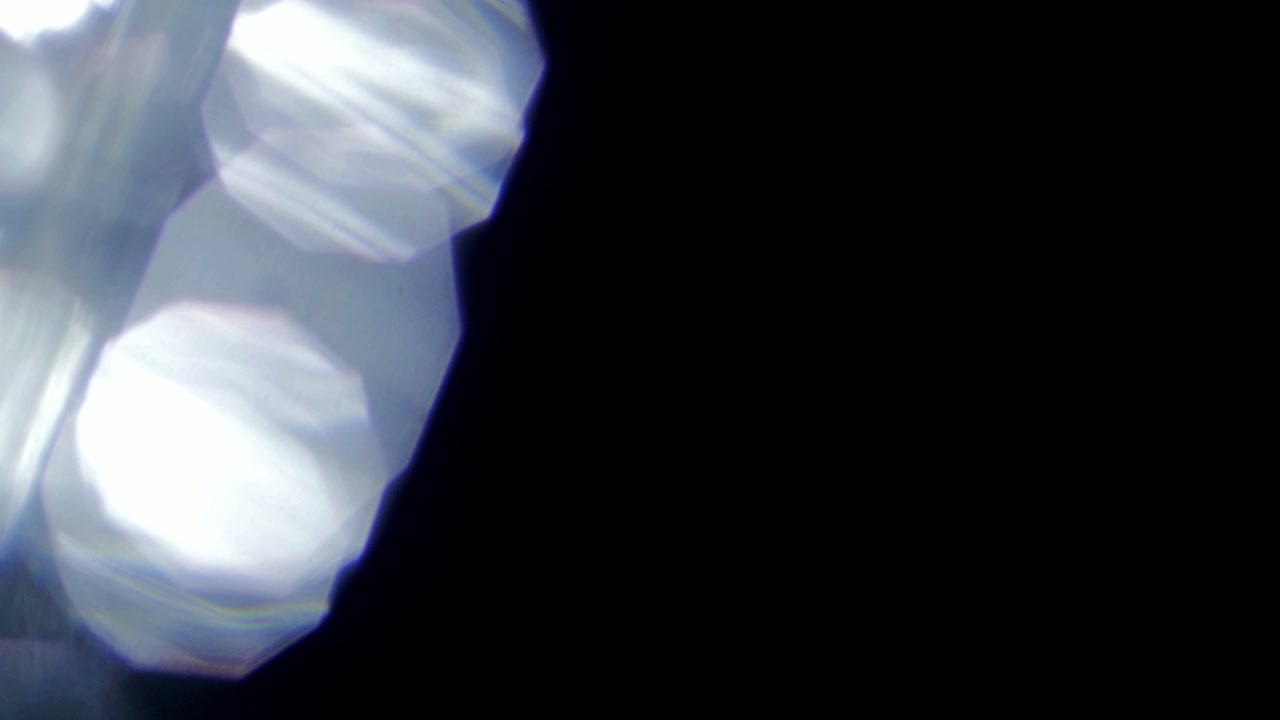 Shimmering Optical Lens Flares Appearing on Dark Screen