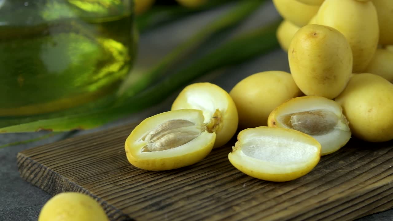 las palmeras de dátiles frescas se colocan en la mesa con aceite, concepto de alimentos saludables. palmeras de dátils. frutas crudas de palmieras de dátiles (phoenix dactylifera)