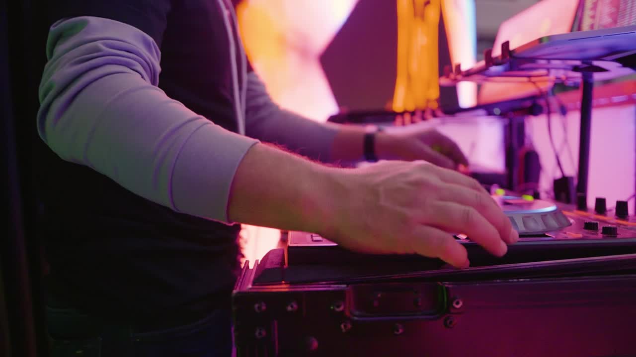 Agile Underground Techno Scene DJ Juggling Track Transition On Turntable At Rave