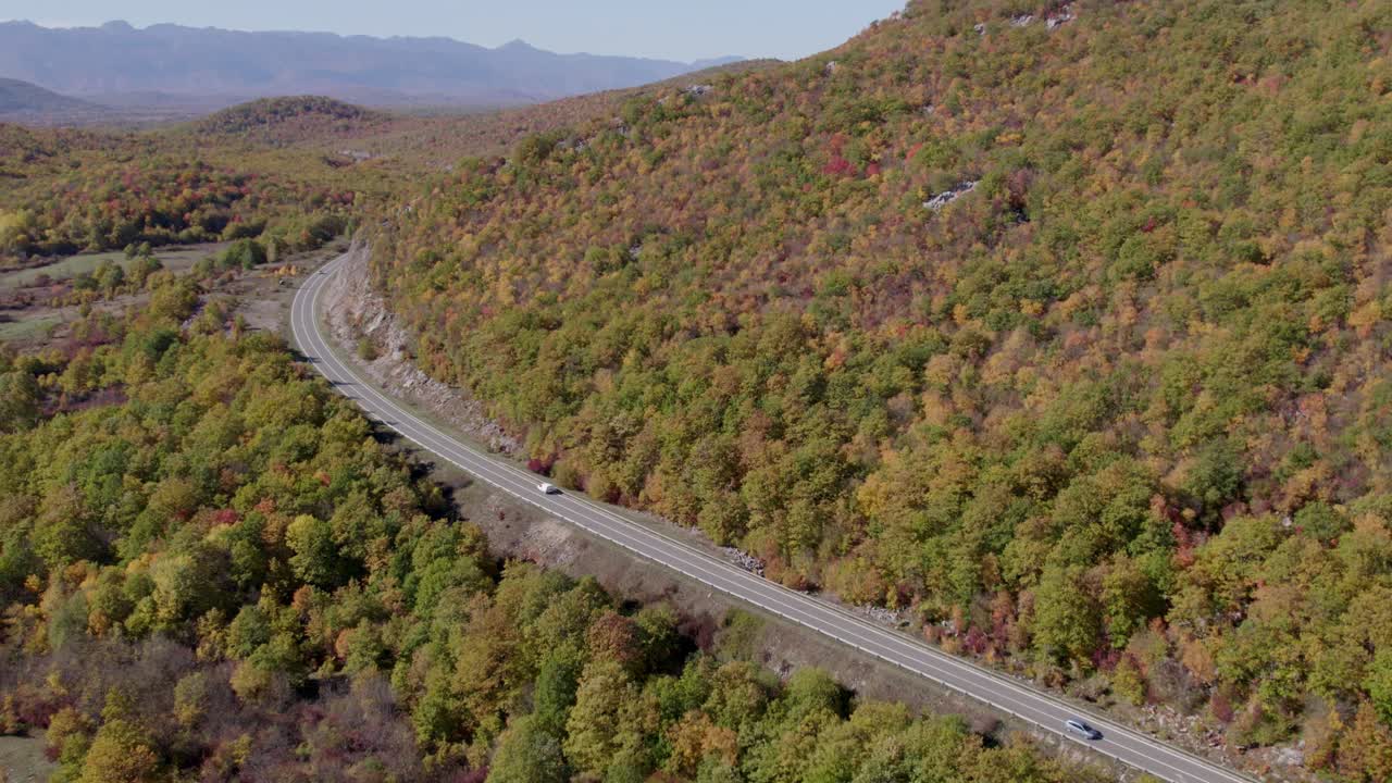 Smukt luftfoto af efterårsbeklædt motorvej med en forbipasserende bil, Udbina, Kroatien