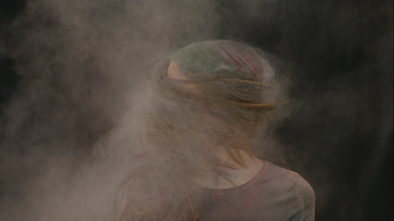 chica en color explosión de polvo en cámara lenta