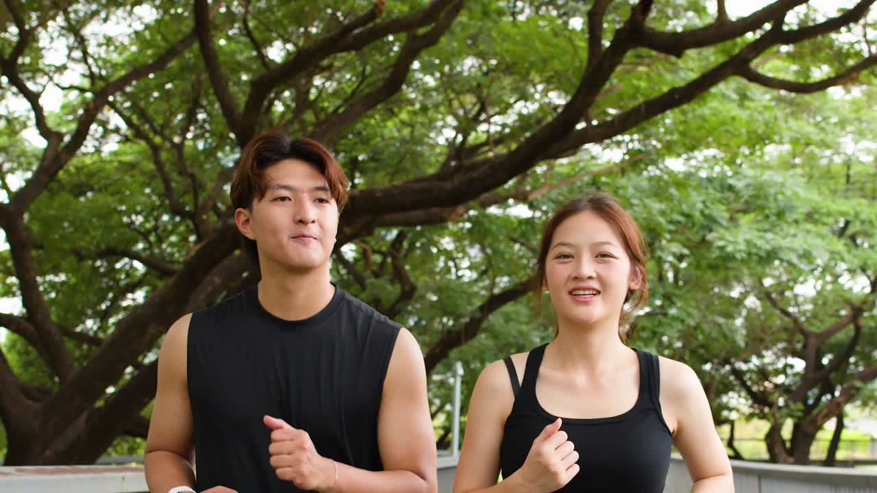 並木のある都市公園を、若い男女が並んでジョギングする幸せそうな姿
