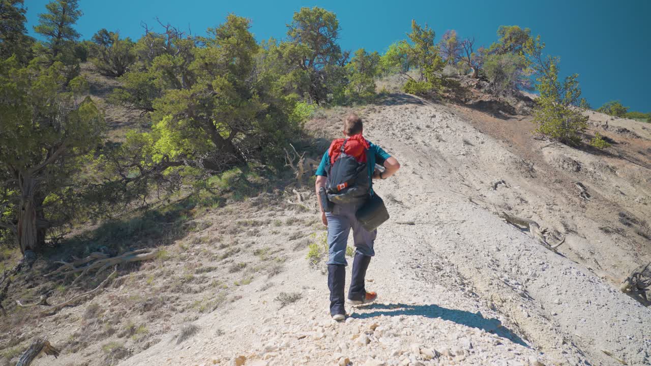 caminante caminando por la empinada pendiente granulosa de azufre | gran montaña de caramelo de roca
