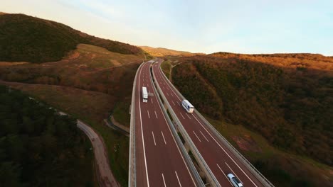 vista aerea dell'autostrada del traffico attraverso una foresta verde durante il tramonto nella stagione autunnale