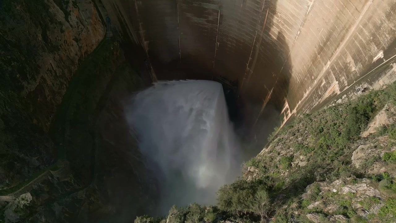 Valvola Howell Bunger in funzione nella diga a volta. Diga che rilascia acqua. Veduta aerea dello scarico dell'acqua dalla diga. Bacino di Quentar. Spagna