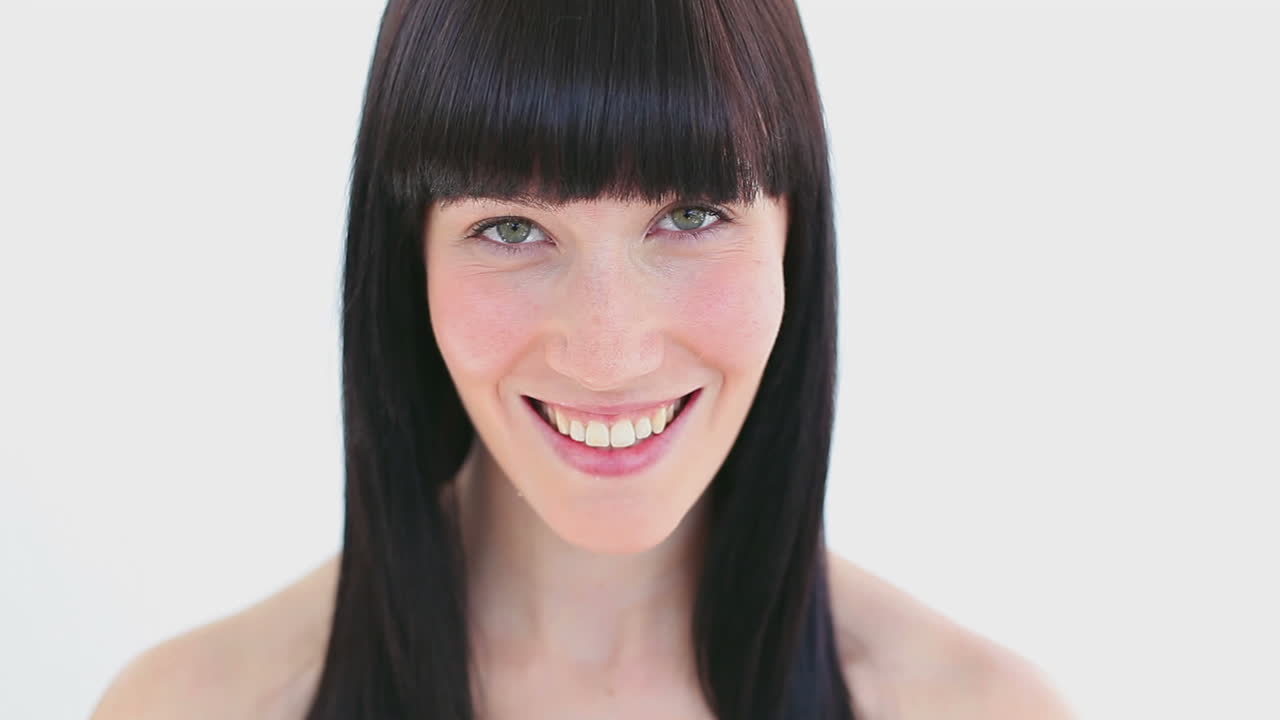 Smiling brunette massaging her two cheeks