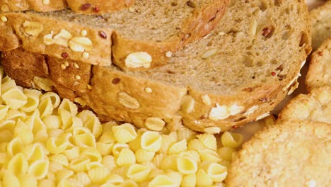 whole wheat bread slices, pasta, and raw corn kernels arranged together in bright lighting, showcasing diverse grains