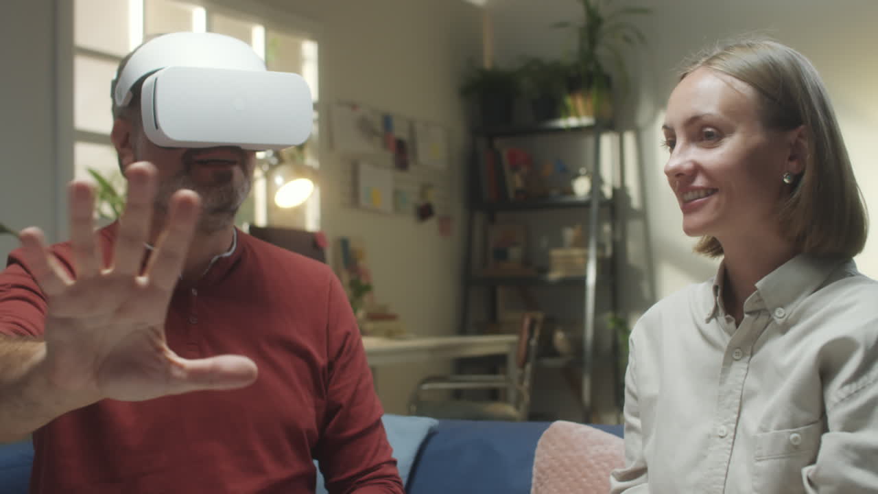 A man in a VR headset interacts with a woman at home