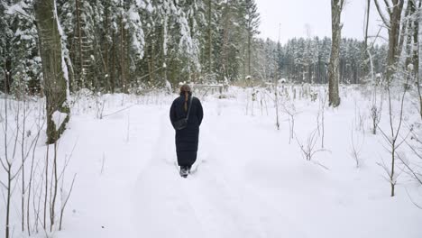 Winter,-Tiefer-Schneefall-Auf-Dem-Boden,-Während-Eine-Eingepackte-Junge-Frau-Weitergeht