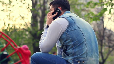 Mann-Benutzt-Smartphone-Auf-Spielplatz.-Junge-Redet-Auf-Dem-Spielplatz-Mit-Dem-Handy