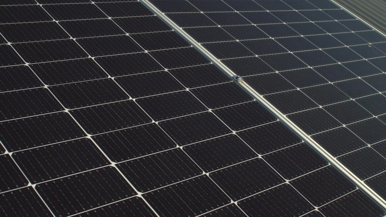 Celle di silicio scure di moderni pannelli solari fotovoltaici installati su un tetto di lamiera ondulata. Primo piano panoramico.
