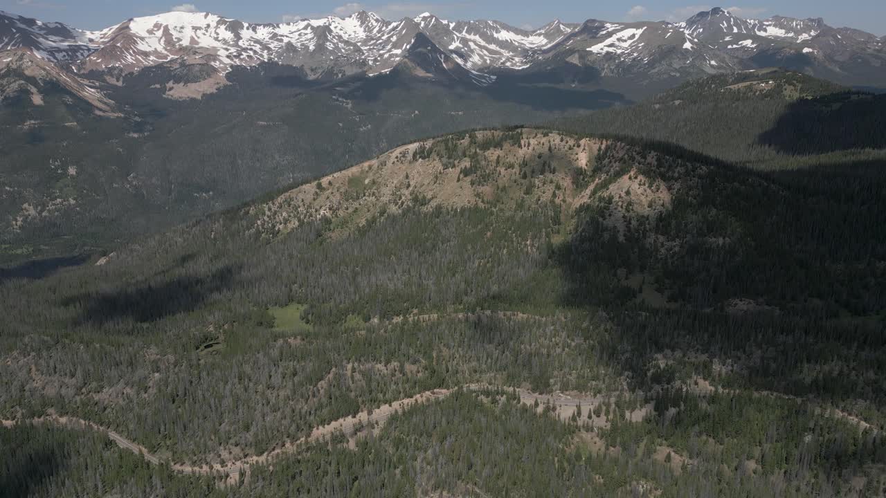 las nubes forman sombras en las montañas rocosas de colorado, la carretera muy por debajo