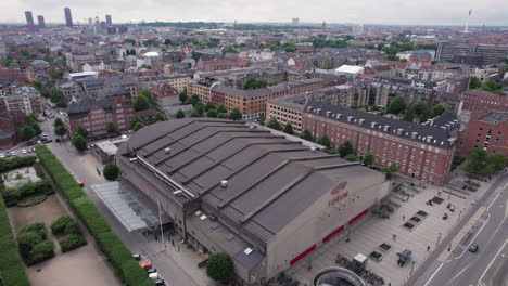 The-Forum-building-captured-from-the-sky,-with-the-cityscape,-buildings,-and-cars-as-its-backdrop