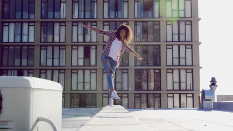 Fashionable-young-woman-on-urban-rooftop-balancing