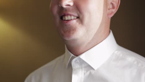 stylish man in jacket fastens buttons, buttoning white shirt preparing to go out near window