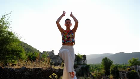 una mujer hace yoga, se estira en un espacio natural