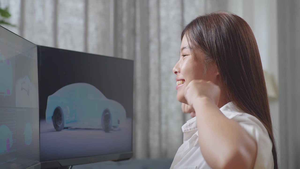 아시아 여성 자동차 디자이너가 목표를 외치며, 성공을 위해 춤을 추고, 스튜디오에서 데스크 컴퓨터에서 ev 자동차의 3d 모델을 작업하는 동안 축하합니다.