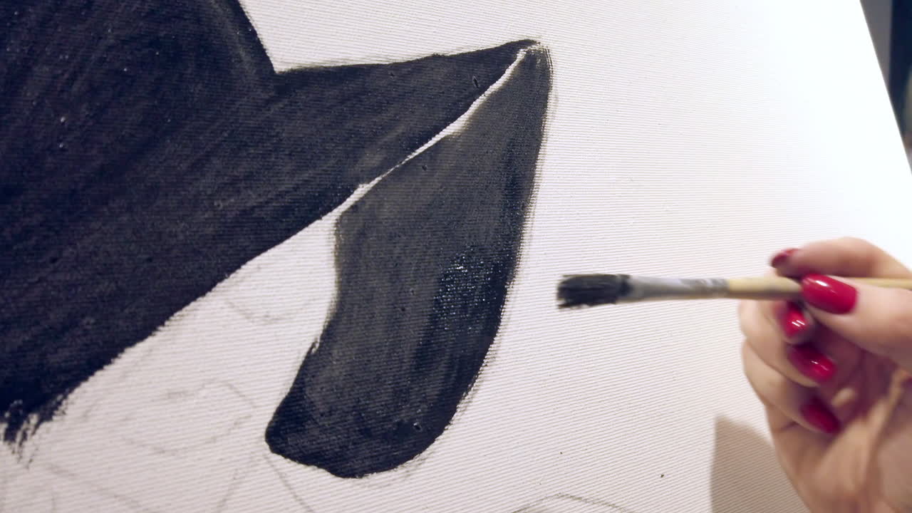 Close up of a woman paining on a paper at an art gallery workshop