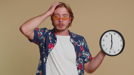 confused man with anxiety checking time on clock, running late to work, being in delay, deadline