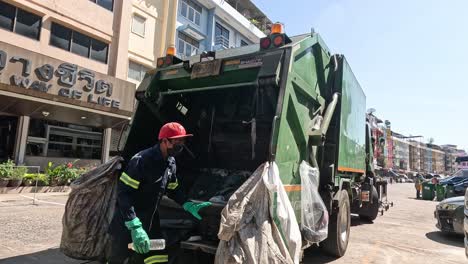 workers loading trash into garbage truck