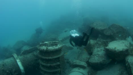 Un-Buzo-Explora-Una-Red-De-Tuberías-Submarinas-En-El-Fondo-Del-Océano