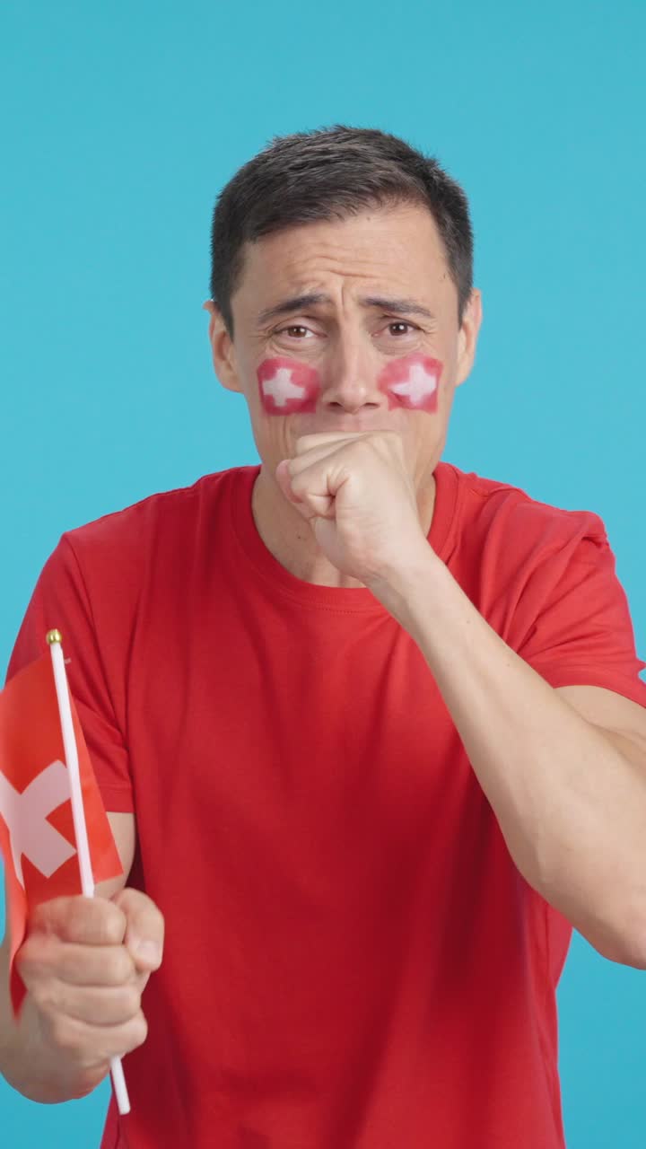 Man cheering for Switzerland during a match that is lost
