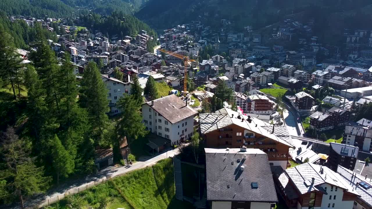 Township buildings of Zermatt on sunny warm day, aerial drone view