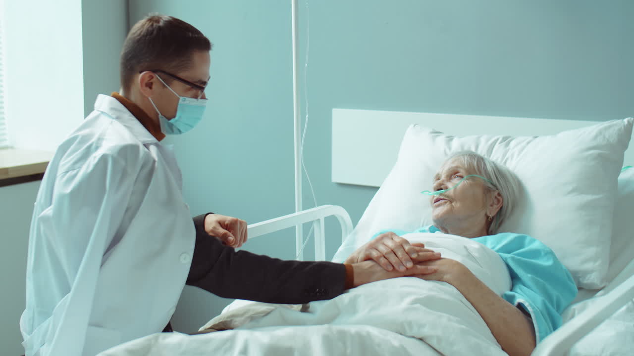 hombre con máscara visitando a una madre anciana en el hospital