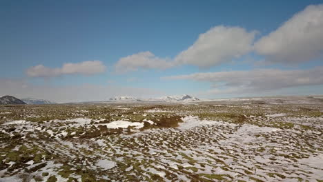 cinematic drone shot flying over the landscape near selfoss iceland with mountains in the distance