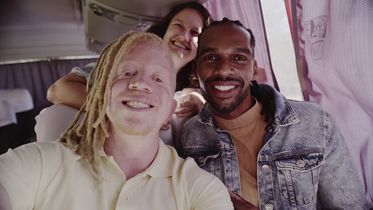Gruppo eterogeneo di amici che si scattano un selfie su un autobus