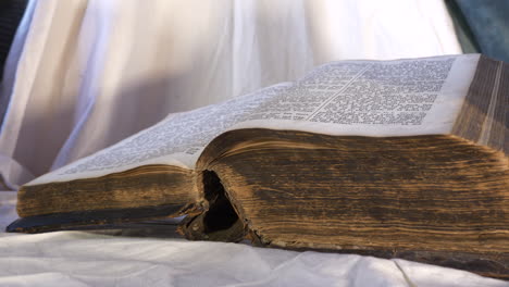 Old-Bible-book-on-altar,-slider-left