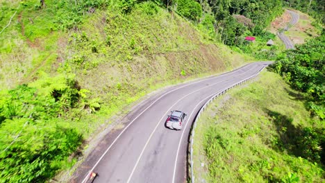 two cars pass each other driving down winding road