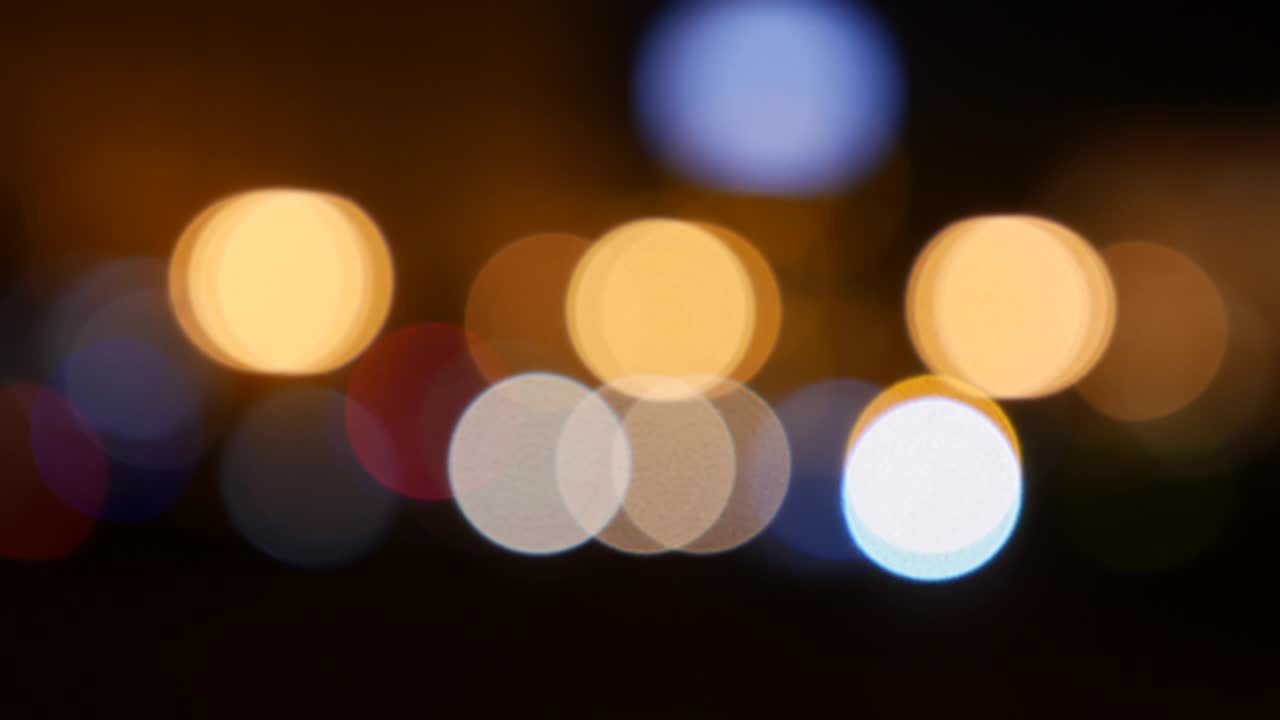 hermoso bokeh brillante en el fondo oscuro borroso por la noche. el redondo bokeh colorido brilla de las luces de los coches en la calle de la ciudad. fuera de foco con borroso. luces de la ciudad sin enfoque. bokeh de tráfico. concepto abstracto