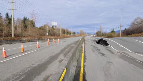 a large sinkhole and destroyed road surface along highway 11, the recent flooding leaving behind extensive environmental damage and erosion resulting in the road collapsing in abbotsford, canada