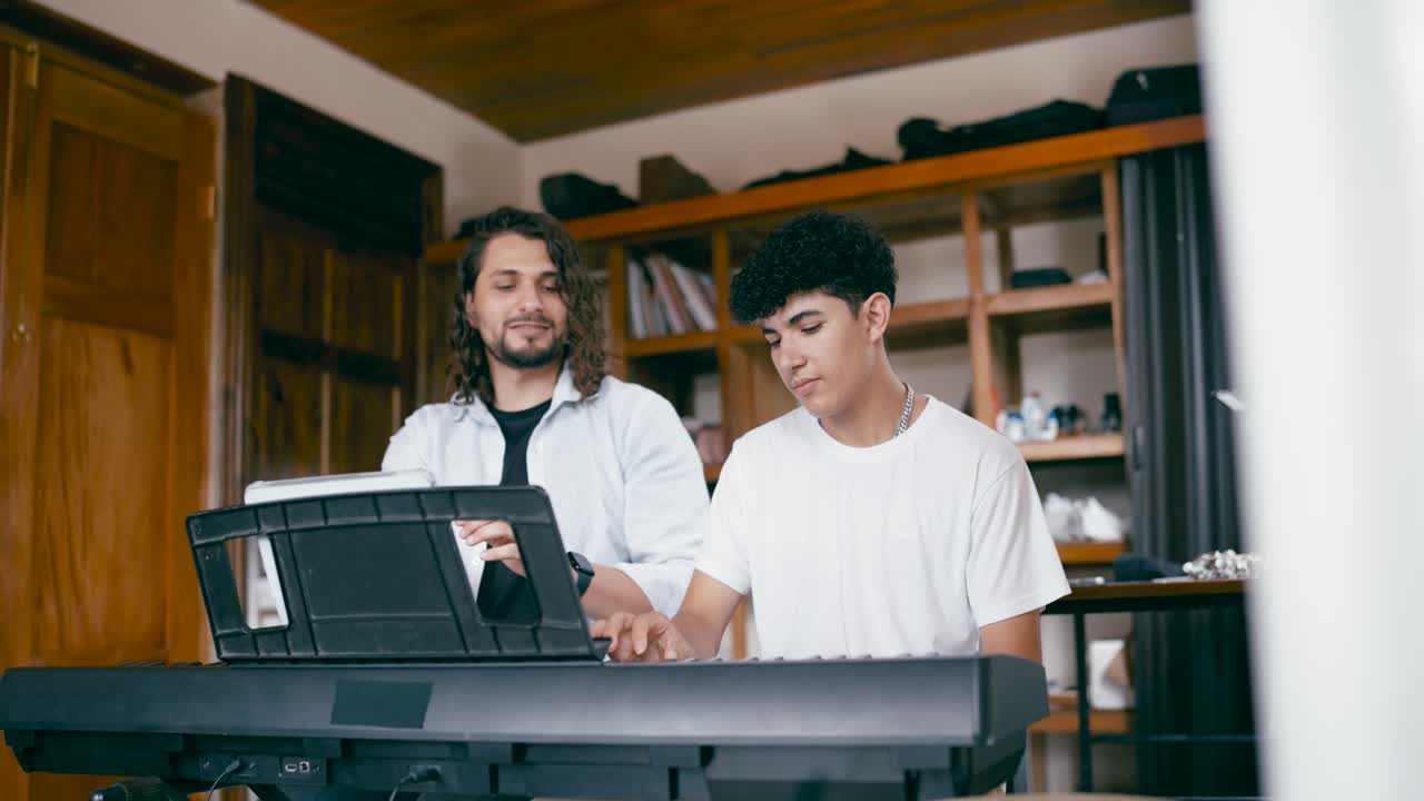 Two men playing a synthesizer
