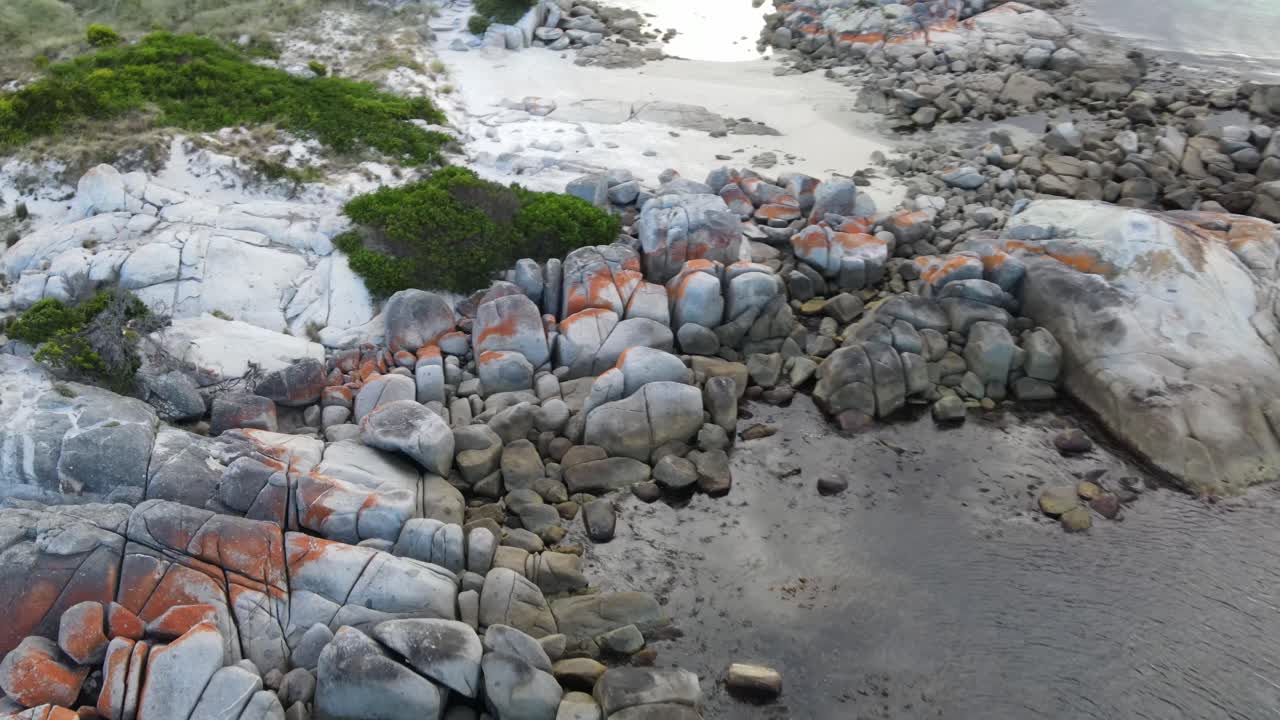 바위 해안에 해변 파도와 함께 화재 바위의 레드 베이로 드론 공중 팬