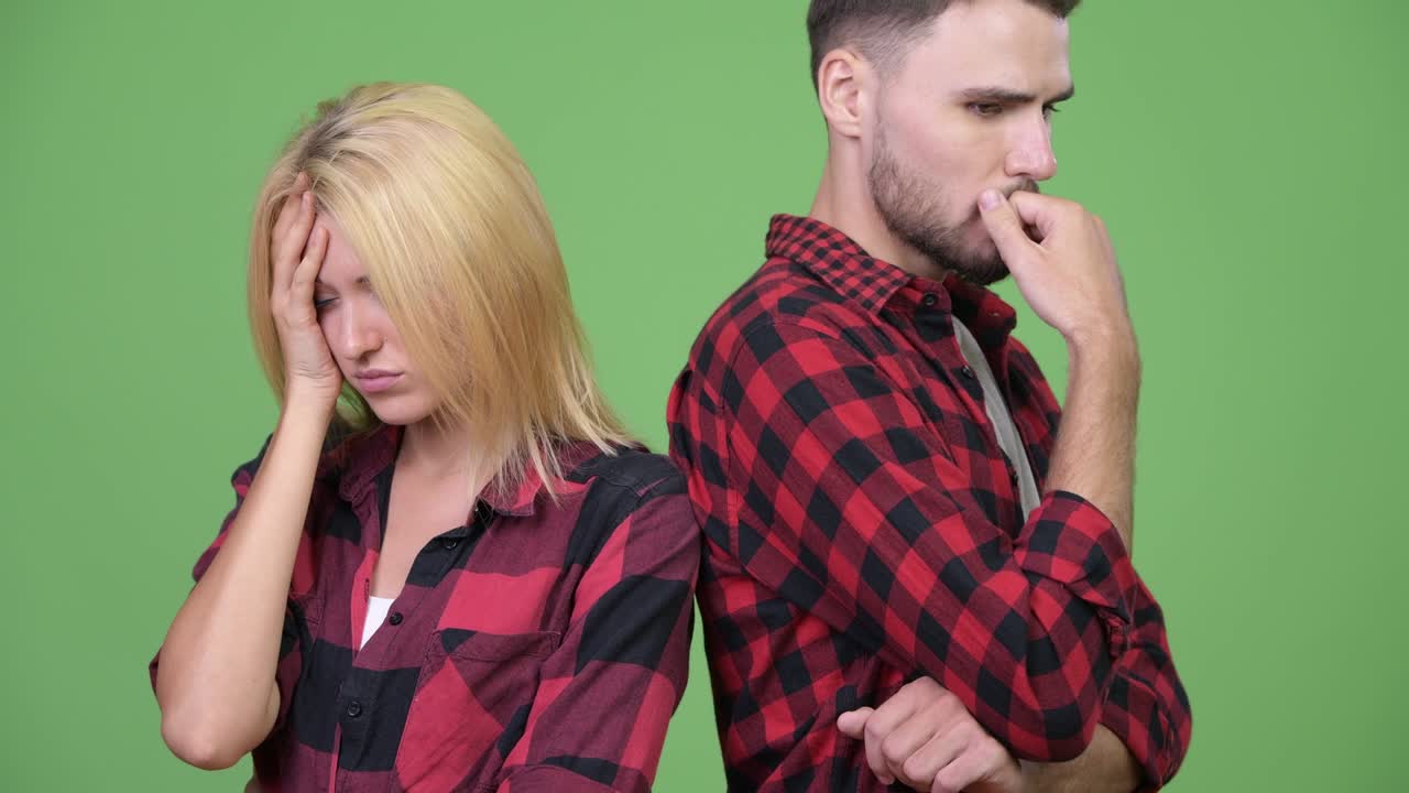 Young stressed couple thinking together with back to back