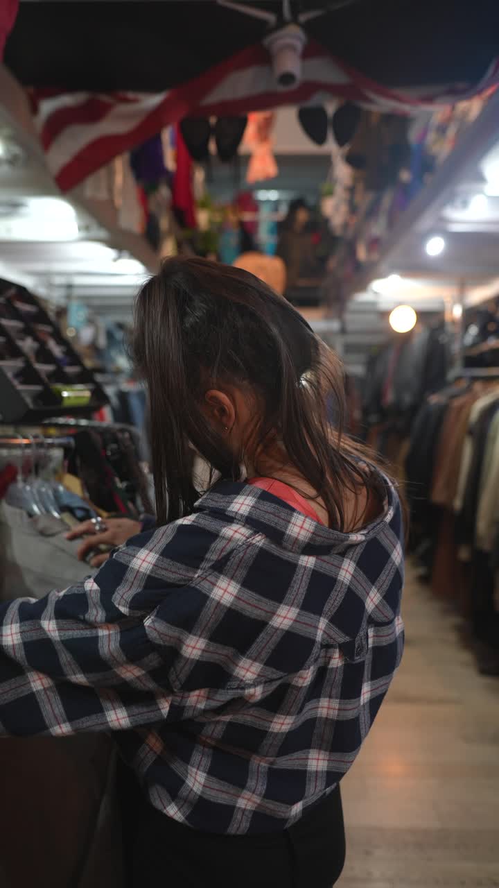 Donna che fa shopping in un negozio di abbigliamento vintage