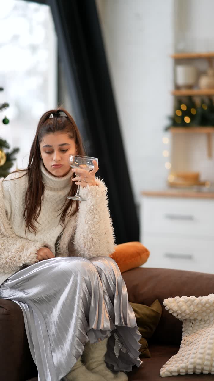 Una donna triste che beve da sola durante il periodo natalizio