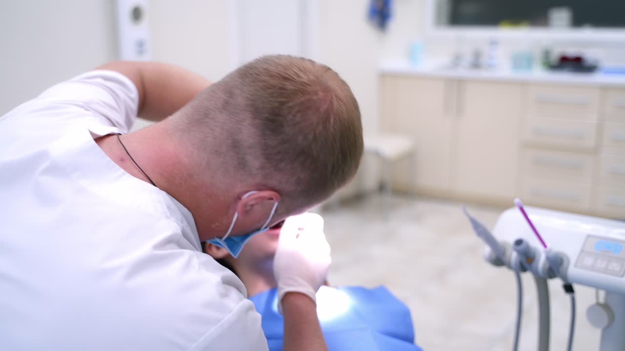 Doctor treats patient teeth in modern dental clinic. Health teeth concept. Young woman in stomatology.