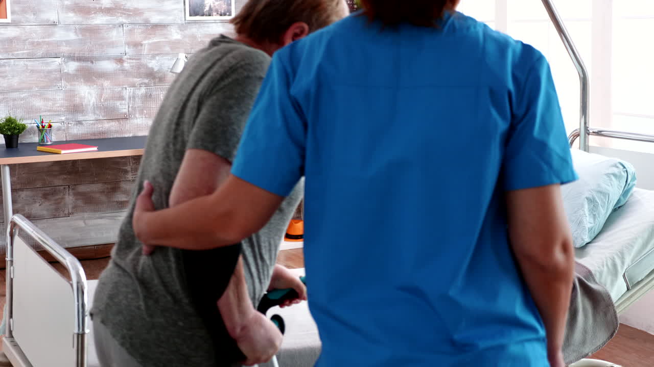 anciana jubilada en un hogar de ancianos caminando con muletas