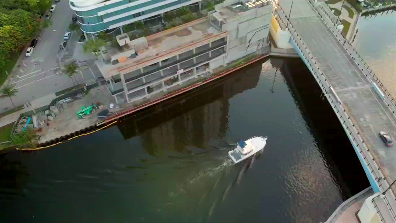 tomada aérea de un barco que va bajo un puente en miami