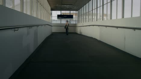 person walking through modern train station overpass