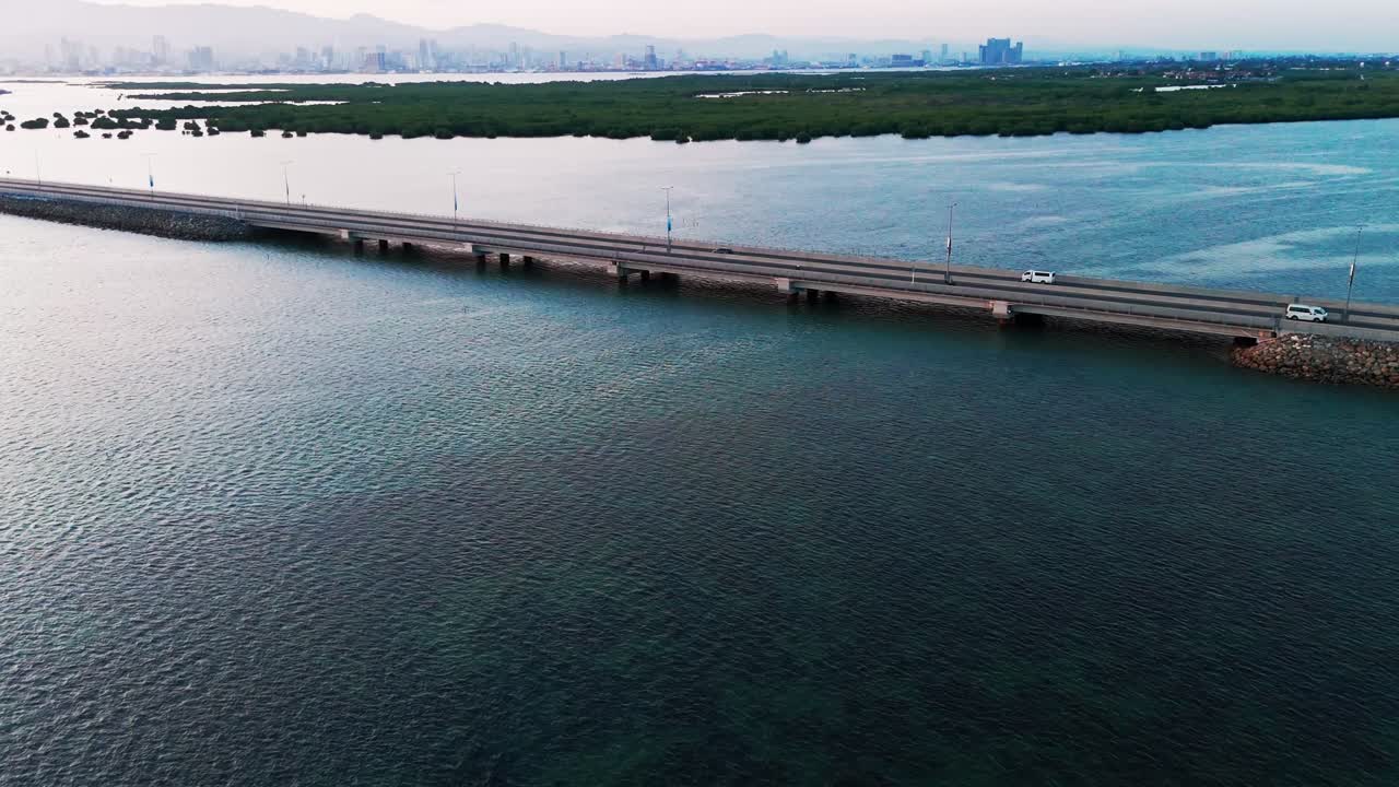 4K aerial drone footage showing a modern bridge crossing blue tropical water with city skyline and mangroves near Cebu, Philippines. Ideal for travel, tourism, real estate, infrastructure,and business
