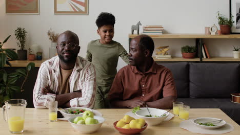 hombres negros y un niño durante el almuerzo