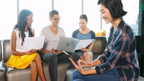 female executive using digital tablet while colleagues working on laptop 4k